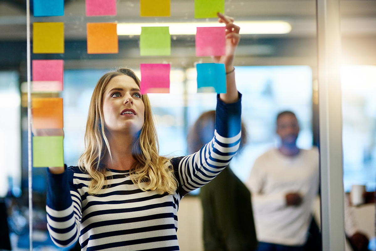 A woman looking at post it notes on a window