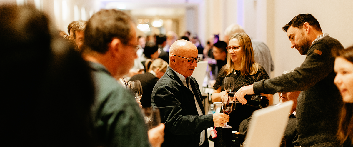 Wine being poured into a glass for a man at an event