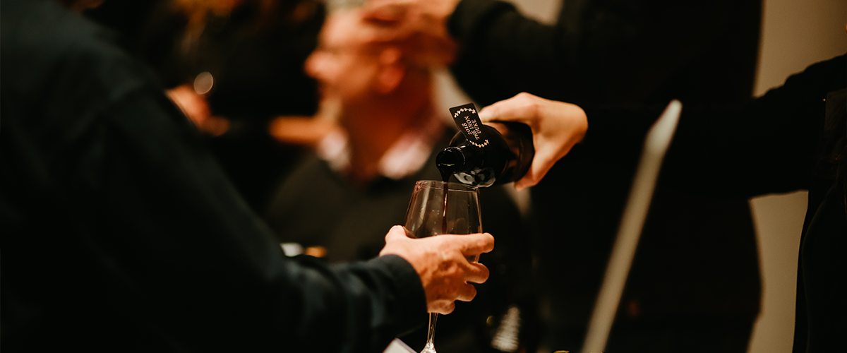 wine being poured into a glass at an event