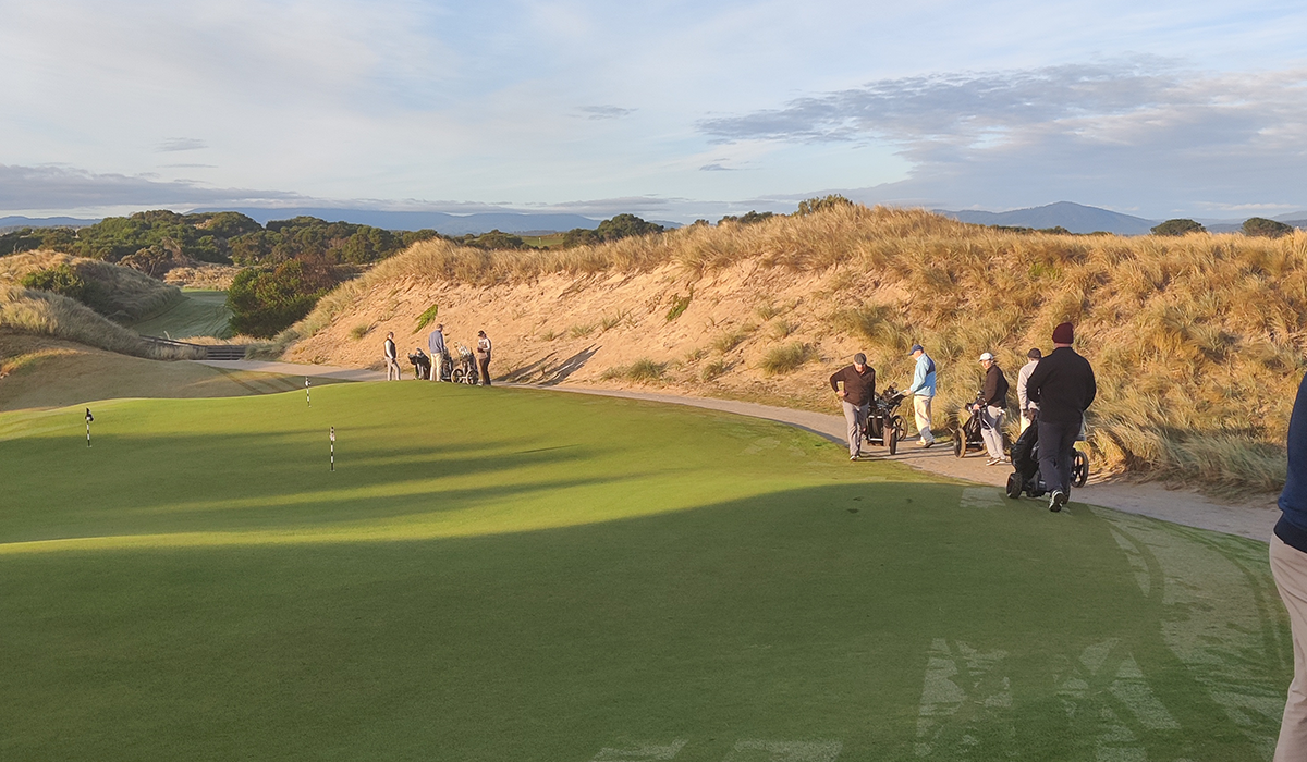 Guests pushing their golf carts around a golf course at Barnbougle in Tasmania