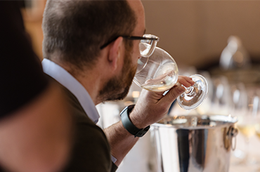 Campbell Mattinson tasting a glass of white wine