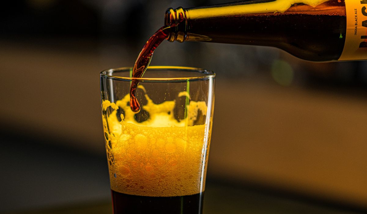 A dark ale being poured into a glass