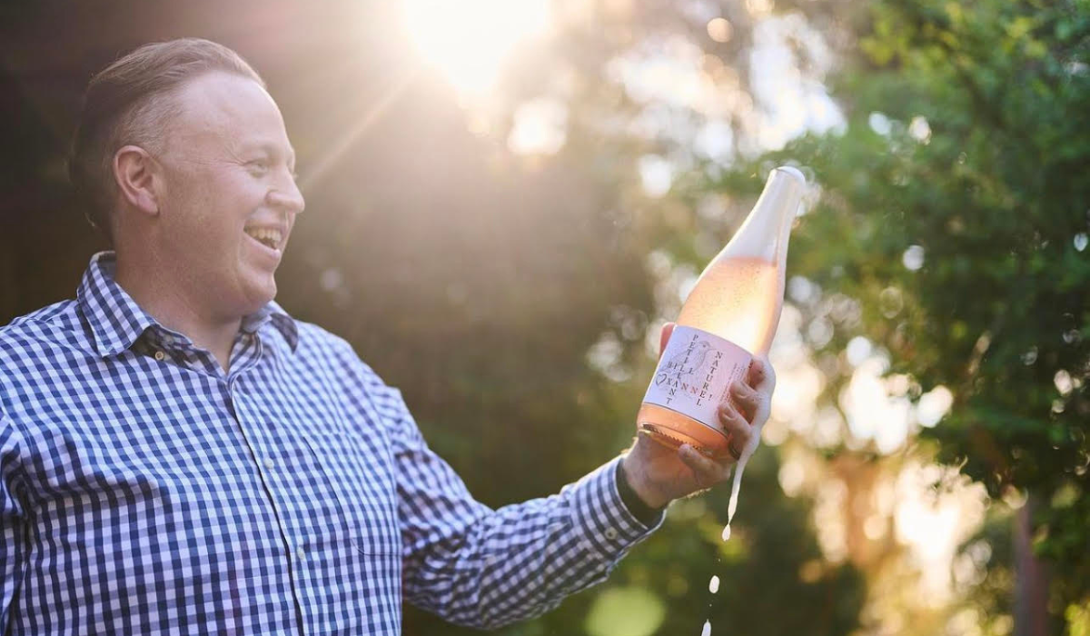 A man opens a bottle of sparkling wine