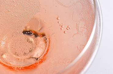 Close up of a pink rosé Champagne glass bubbles