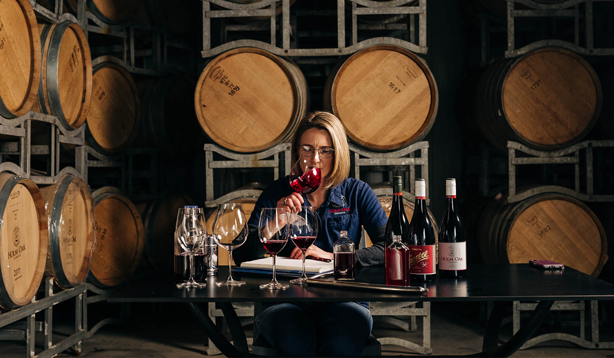 Woman tasting wine in barrel room