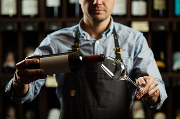Bartender pouring a glass of wine 