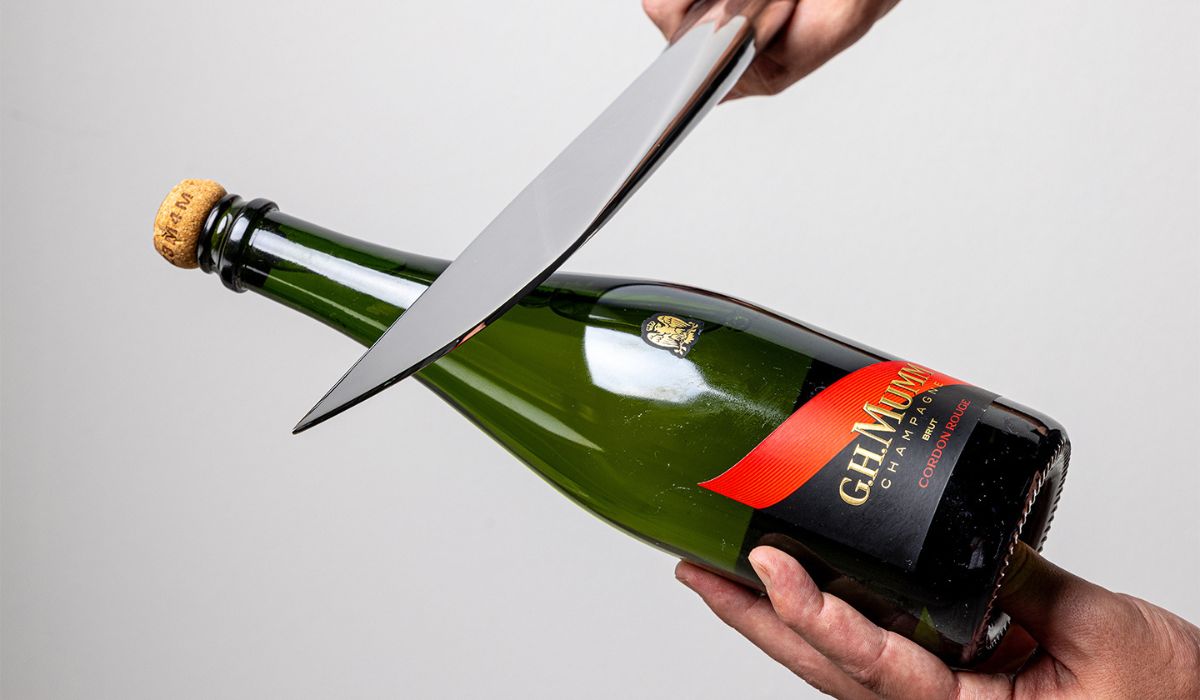 A bottle of Mumm Champagne about to be sabred