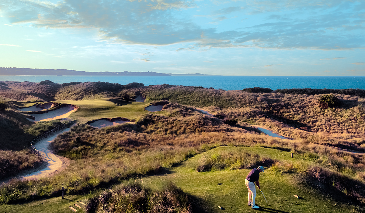 A man teeing off at The Dunes