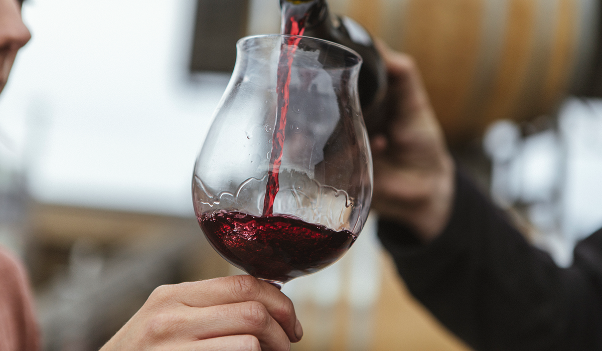 Glass of red wine being poured