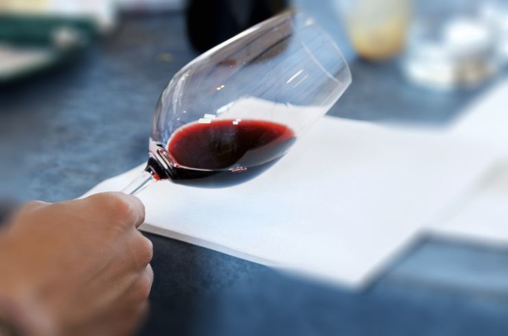 A glass of red wine being assessed in a wine show