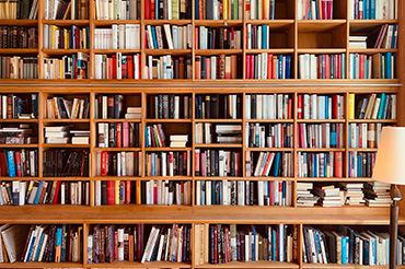 Wooden brown bookshelf with a lamp in the foreground