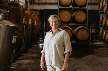 A woman stands in a barrel room
