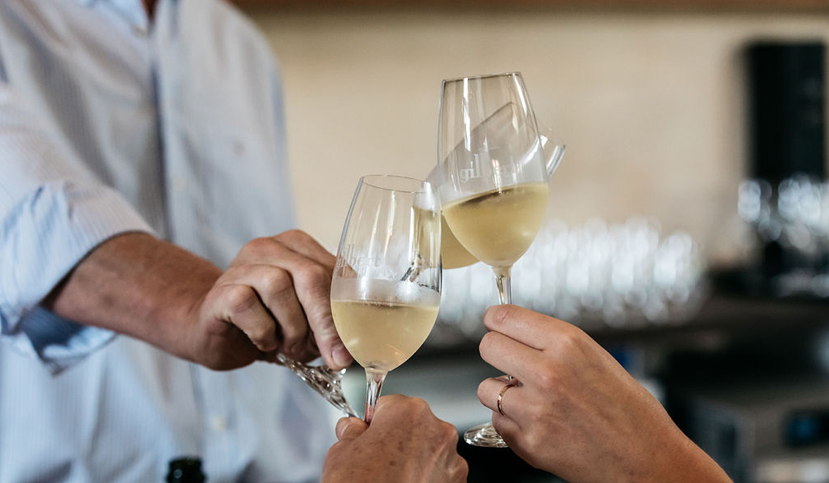 Three glasses of Gilbert sparkling wine being cheersed 