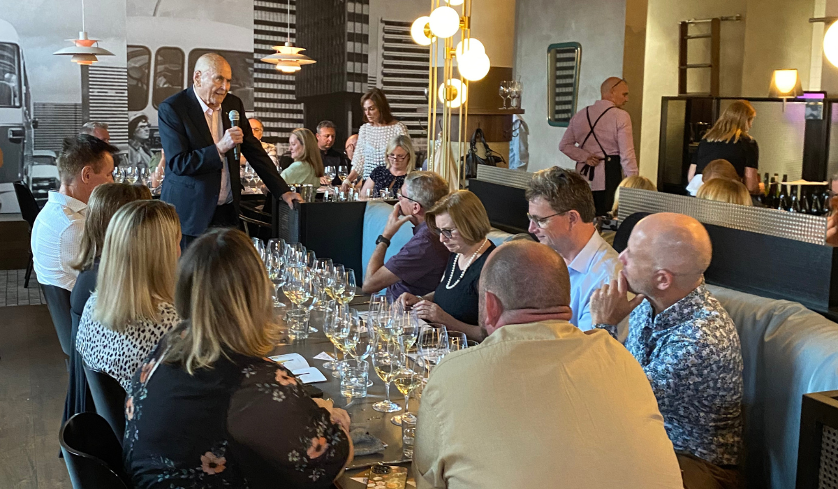 A man talks to a crowd in a restaurant 