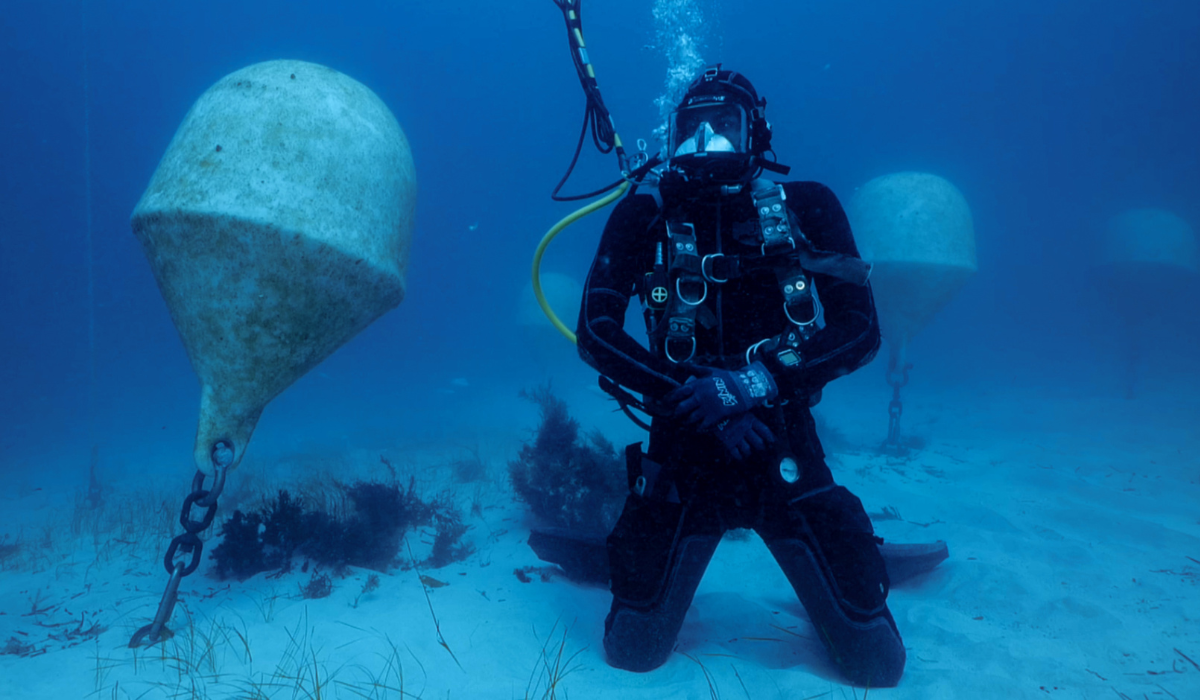A scuba diver checks an underwater wine vat