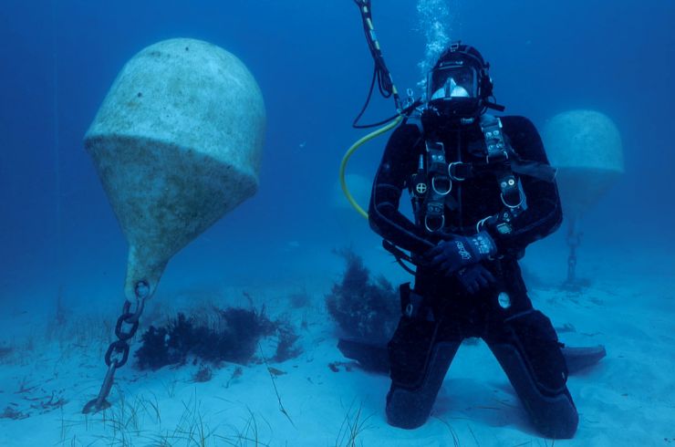 A scuba diver checks an underwater wine vat