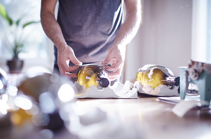 A wine bottle being labelled by hand