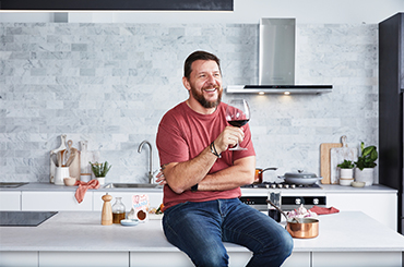 Chef Manu Feildel with a glass of wine