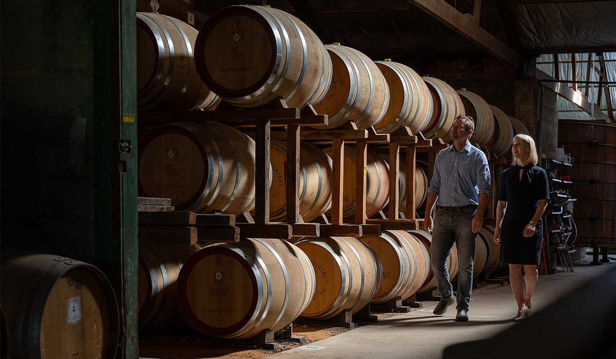 Richard and Victoria Angove walking past barrels