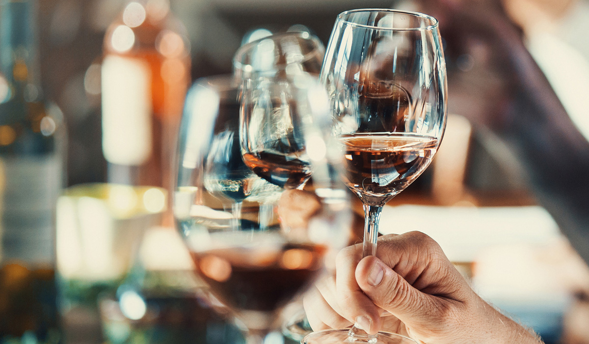 Hands holding wine glasses at a tasting