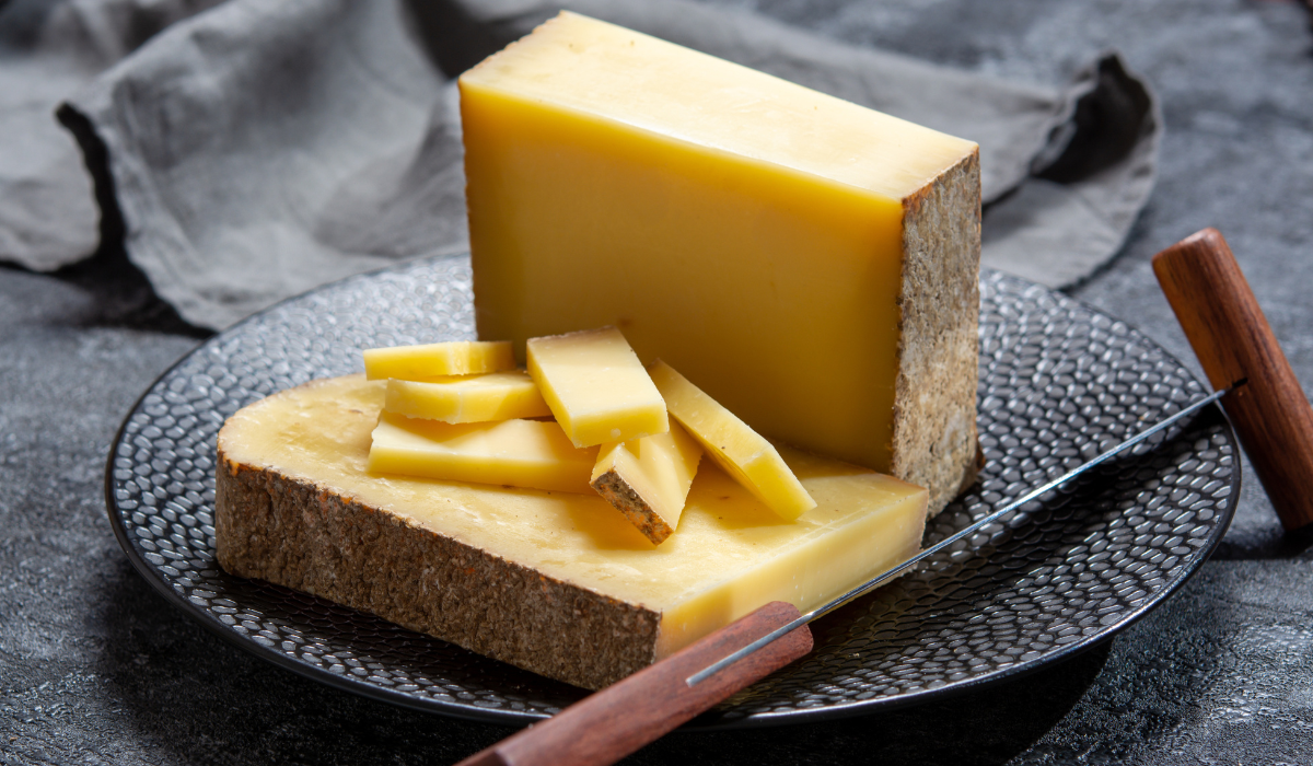 A block of cheese, partially sliced