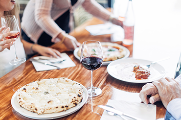 A bianco pizza with a glass of red wine