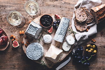 Cheese and wine spread with bread, olives and figs