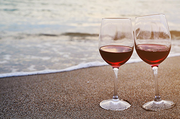 Two glasses of red wine on the sand by the sea | Red wine summer