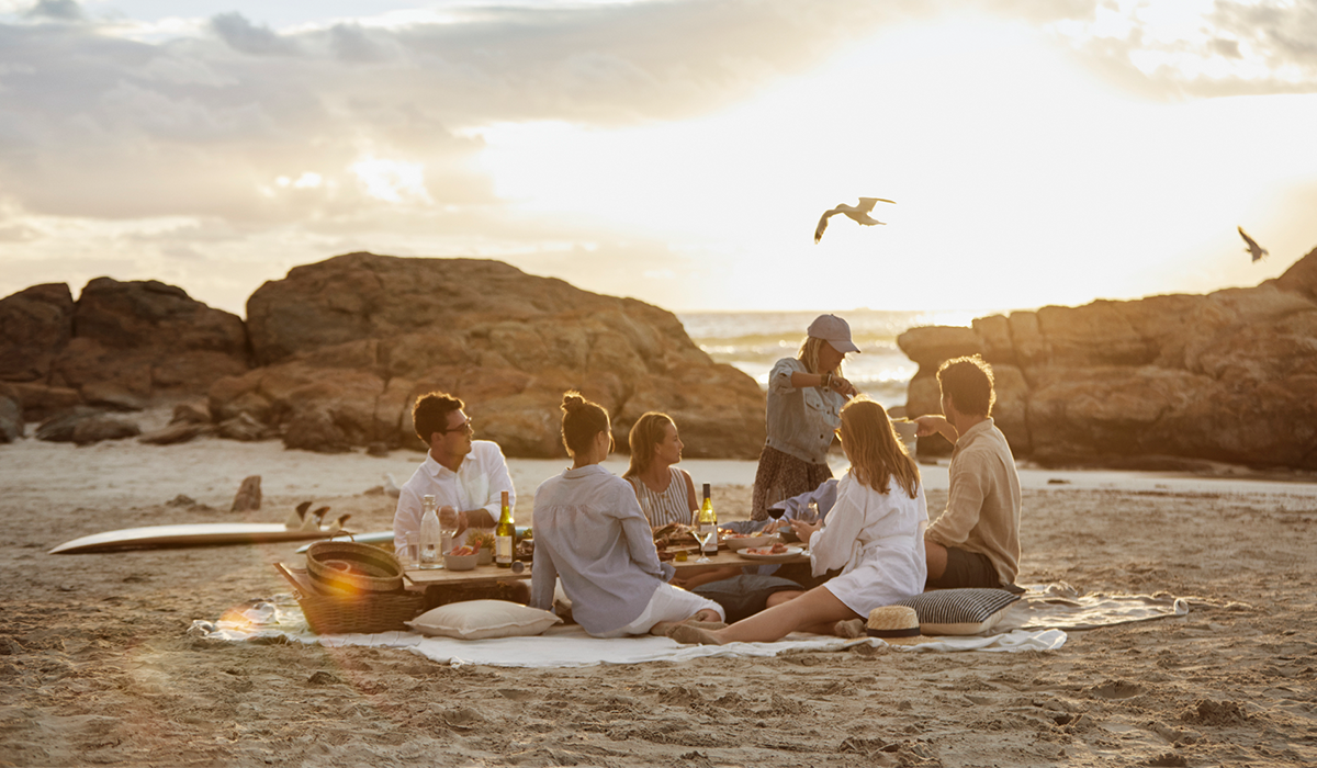 People having picnic with wine on beach