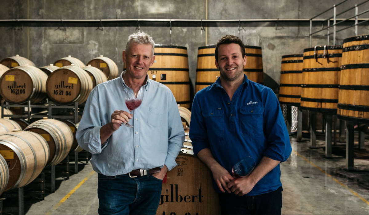 Two male winemakers in a barrel room