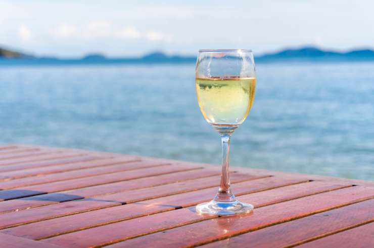A glass of white wine in front of the sea