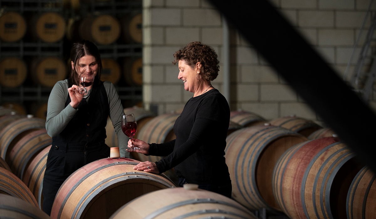 Lauren Hansen and Kate Goodman in the winery tasting wine from the barrels