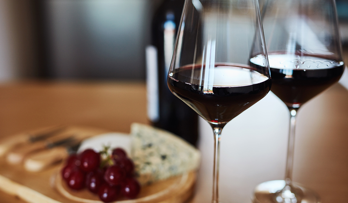 Shot of wine and a cheese platter on a kitchen counter