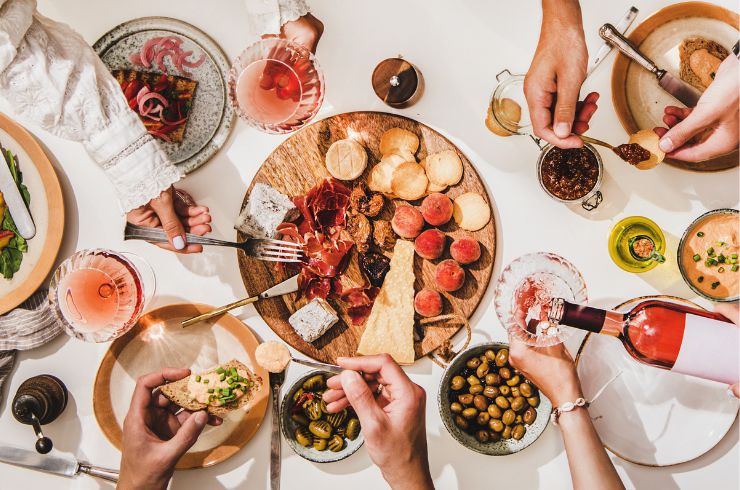 Lots of food and wine on a table.