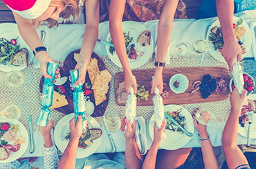 Group of people pulling Christmas crackers