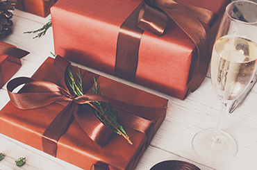 Christmas present boxes on white wood background with glass of wine