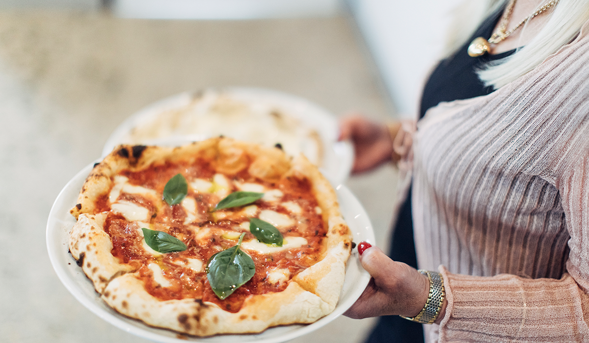 Pizza being carried to a table