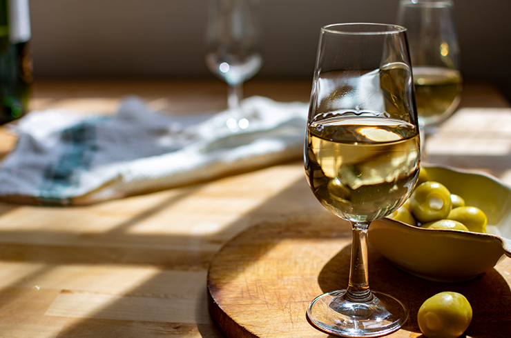 A glass of sherry with a side of olives